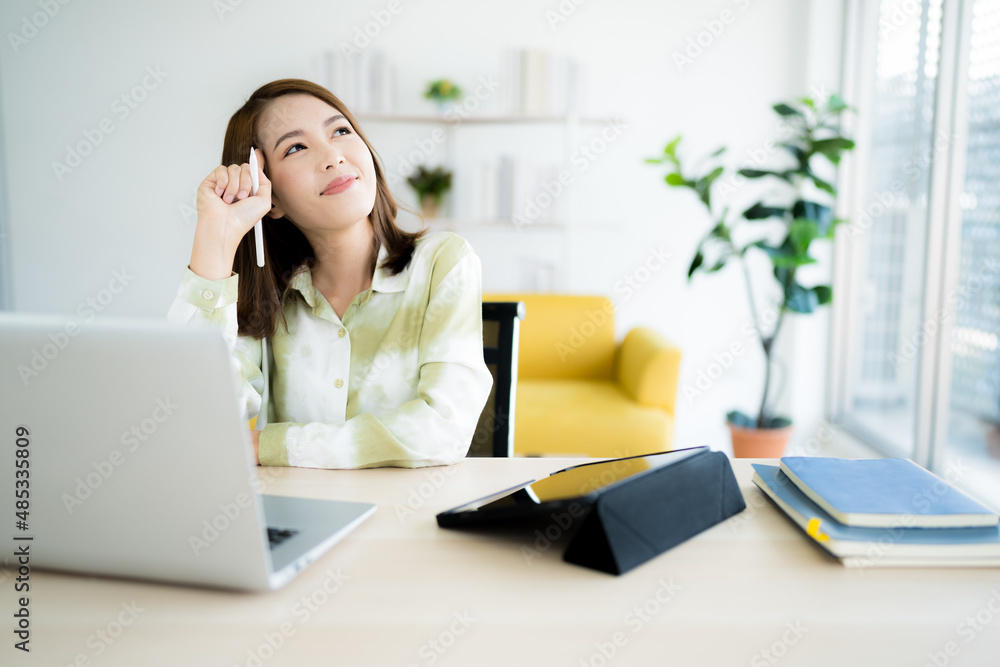 A photo of a bright Asian business woman working at home in the room. The idea is Work form Home Finance Marketing Bright Portrait Simple A photo of a bright Asian business woman working at home in the room. The idea is Work form Home Finance Marketing Bright Portrait Simple