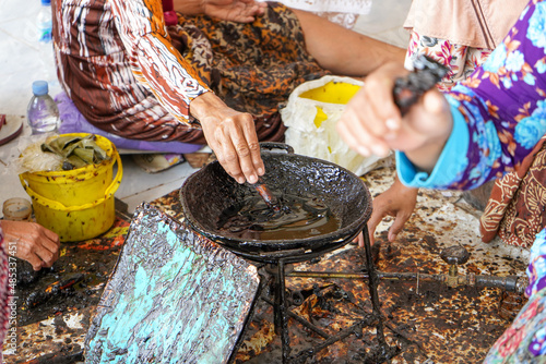 The technique of making batik by writing using a canting tool. Canting consists of nyamplung, cucuk, gagang or handles made of copper, bamboo and wax. Cecek, loron, telon, prapat, telon, liman, byok. photo