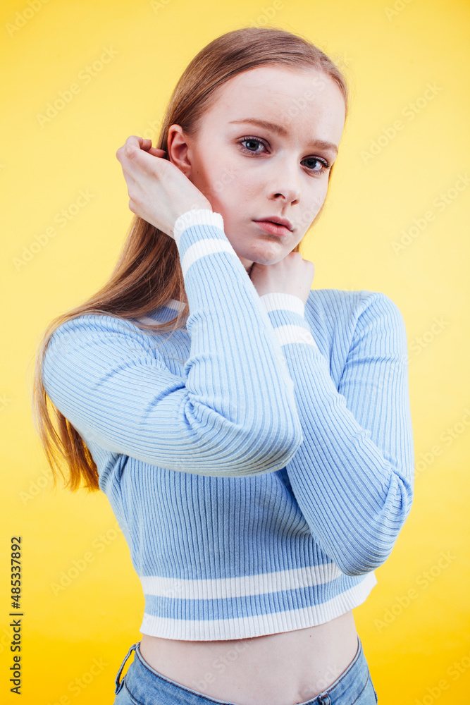 young pretty teenage girl emotional posing on yellow background, fashion lifestyle people concept young pretty teenage girl emotional posing on yellow background, fashion lifestyle people concept