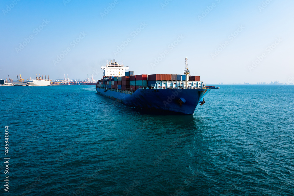 Aerial front view container cargo ship carrying commercial container in import export business commerce logistic and transportation of international by container ship