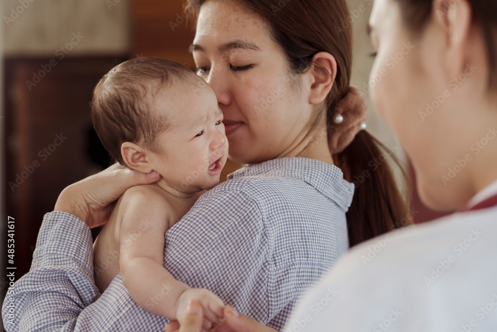 A newborn baby is crying on her mother's shoulder for fear of the doctor coming to check because she is sick in the hospital. A newborn baby is crying on her mother's shoulder for fear of the doctor coming to check because she is sick in the hospital.