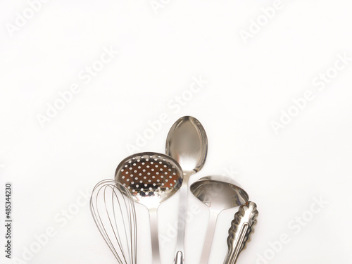 Set of metal kitchen utensils isolated on white background with copy space. Stainless steel kitchen appliances.