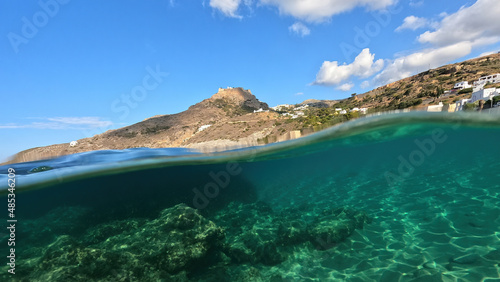 Underwater split photo taken from beautiful emerald bay and beach of Kapsali overlooking famous castle of Kythira island, Ionian, Greece photo
