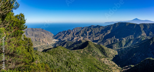 Wanderurlaub auf LA GOMERA, Kanarische Inseln: Panoramablick von Frau vom Mirador bei Wanderung im Lorbeerwald, Nationalpark Garajonay auf Vallehermoso, Teide im Hintergrund photo