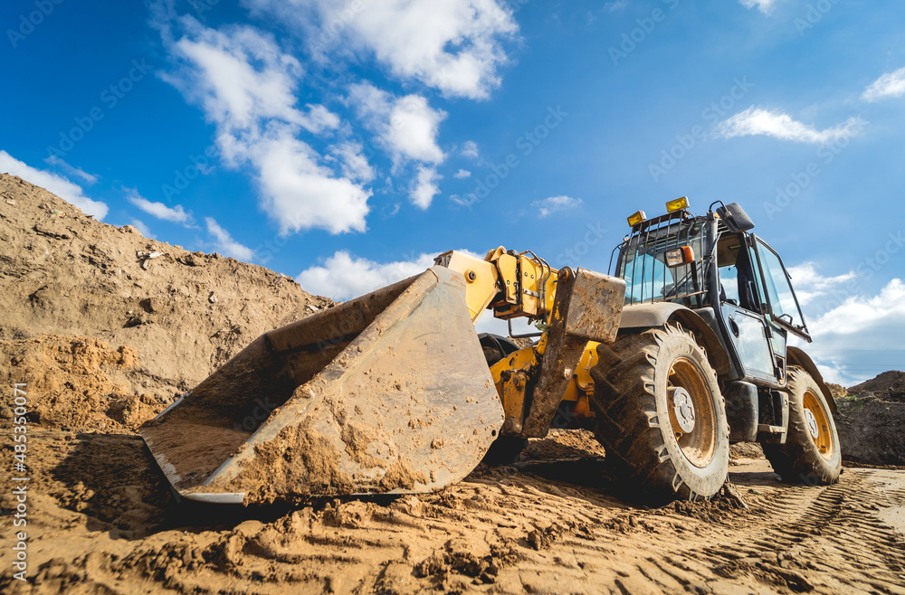 Obraz premium Wheel loader excavator works at construction site