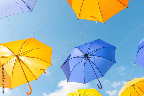 Colourful umbrellas urban street decoration, hanging colourful umbrellas on the blue sky, tourist attraction