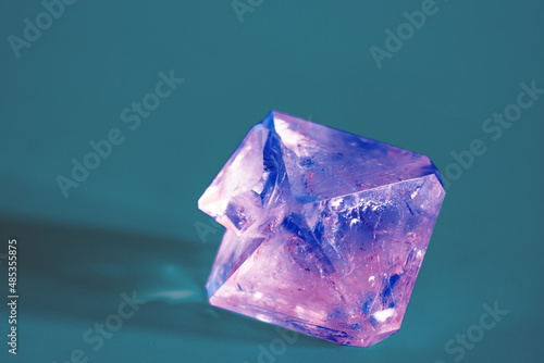 Fotografi Natural crystal of the mineral corundum on a blue background