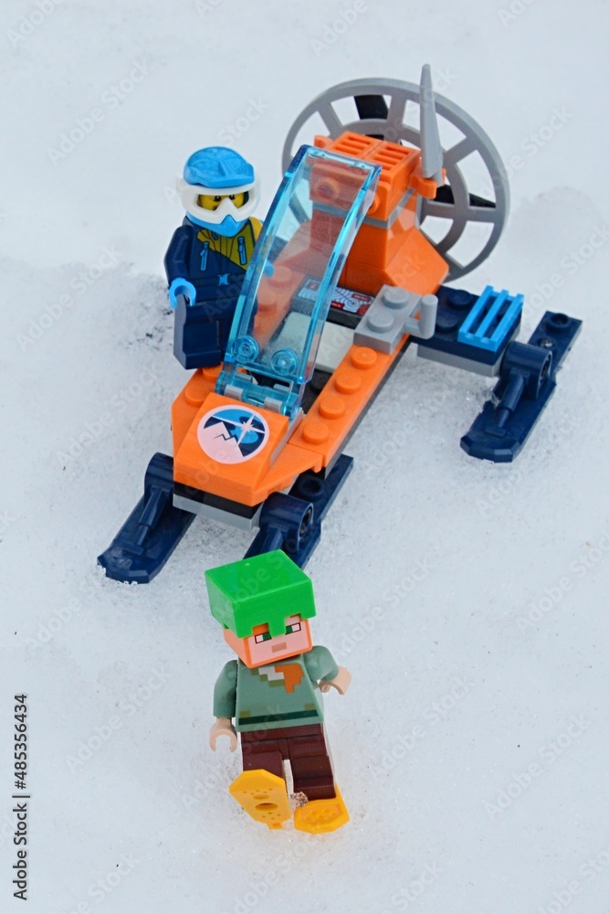 LEGO Creator Snowmobile driver in sport helmet watching LEGO Minecraft Alex figure as she walks