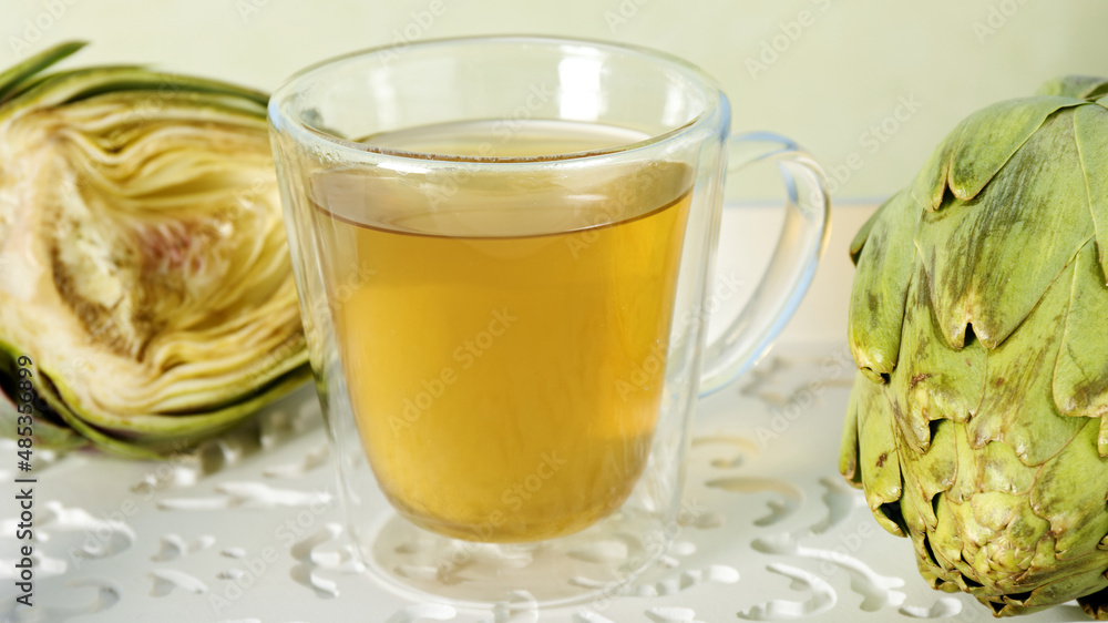 Artichoke tea glass cup. Raw artichoke vegetables with herbal beverage. Artichoke tea glass cup. Raw artichoke vegetables with herbal beverage.