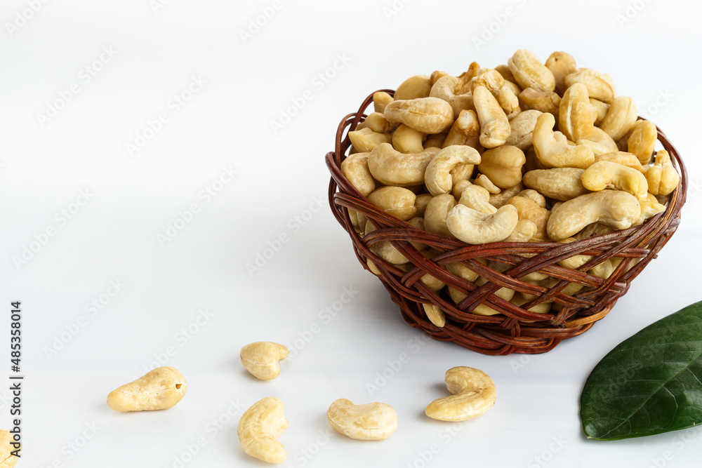 Dried cashew nuts in wicker basket on white background Dried cashew nuts in wicker basket on white background
