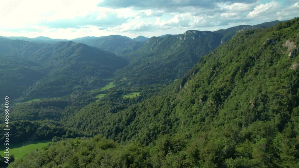 AERIAL: Scenic aerial view of the vast valley in Slovenia, Europe covered in lush green forests. Flying over the untouched woods high in the remote Slovenian mountains. Picturesque green mountains. AERIAL: Scenic aerial view of the vast valley in Slovenia, Europe covered in lush green forests. Flying over the untouched woods high in the remote Slovenian mountains. Picturesque green mountains.