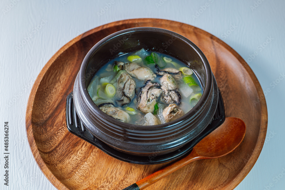 Gulguk, Korean style oyster soup : made by boiling fresh oysters with radish, bean curd, onion, anchovy, and mushroom. Add brown seaweed and chive to the soup to remove the fishy smell oysters are kno - obrazy, fototapety, plakaty 