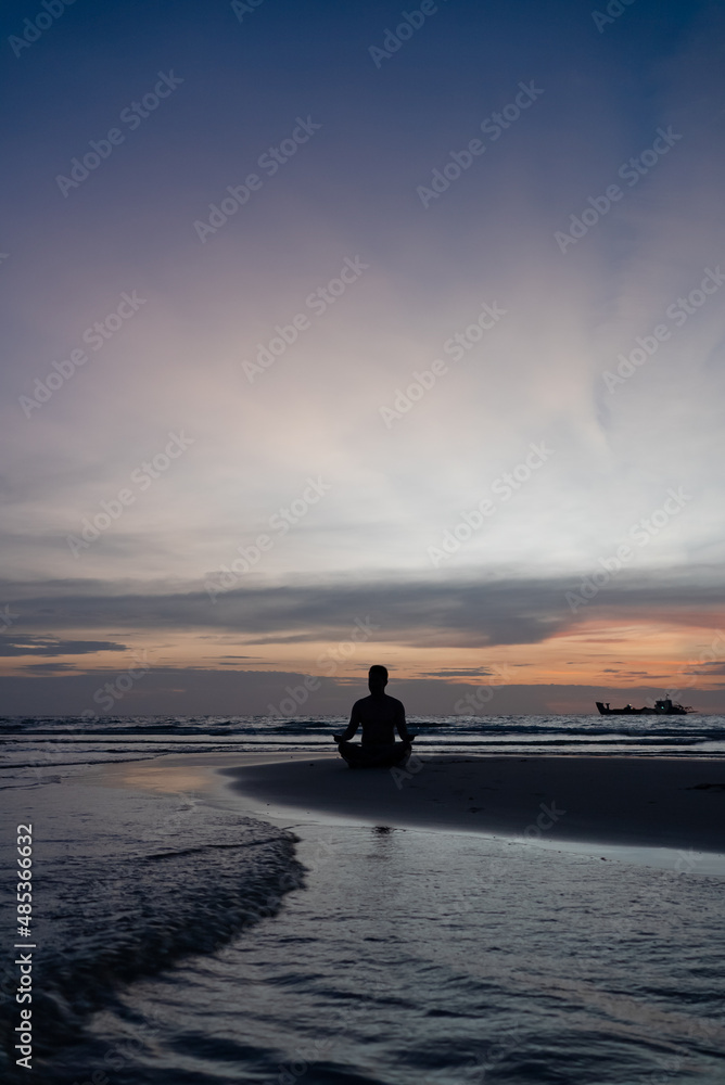 Silhouette of Man Meditate on Beach at Sunset