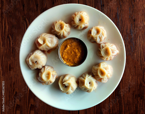 Steam-cooked momos with sauce, Nepalese Traditional Dish Momo. Steam momos on the wooden background.
