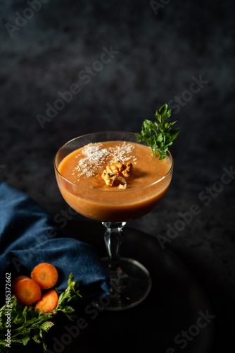 Smoothie made of carrot, nutmeg, ginger, cinnamon, banana, coconut milk on a dark background. A healthy diet.