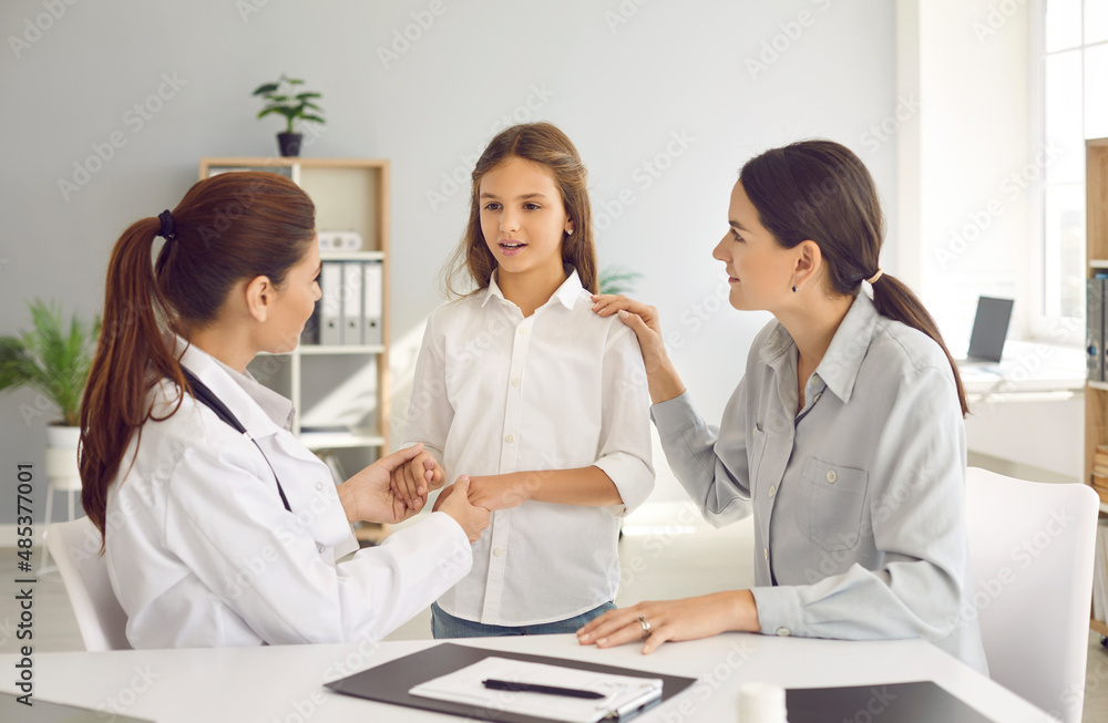 Parent and child talking to family doctor. General practitioner holding kid by hands during interview. Pediatrician listening to little girl who came to hospital with her mother. Trust concept Parent and child talking to family doctor. General practitioner holding kid by hands during interview. Pediatrician listening to little girl who came to hospital with her mother. Trust concept
