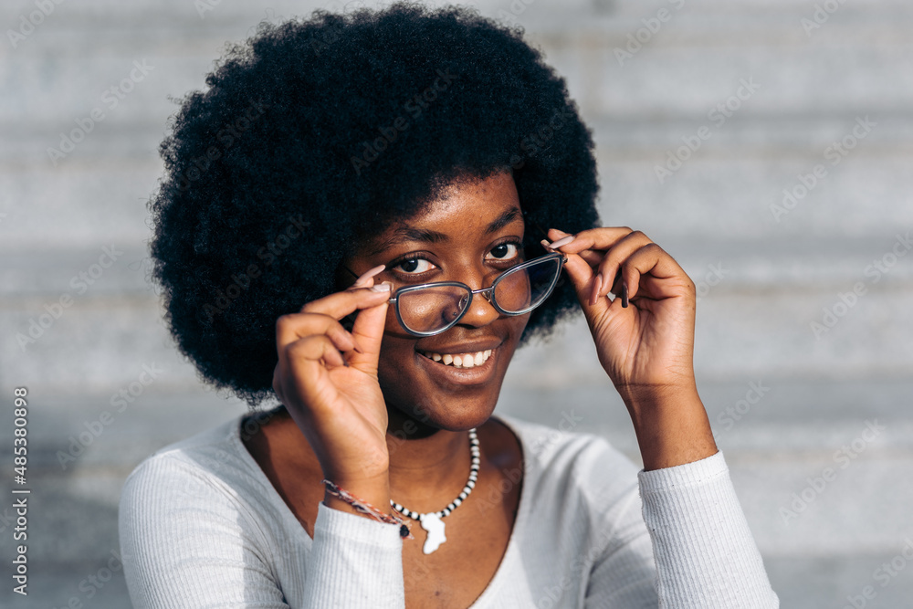 Young black teenage student putting on glasses smiling Stock Photo | Adobe  Stock