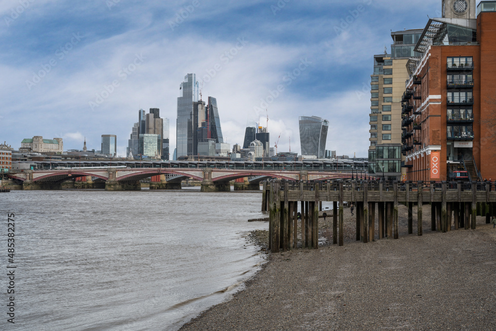 The iconic skyscrapers skyline of Liverpool Street in London across a pier by the River Thames