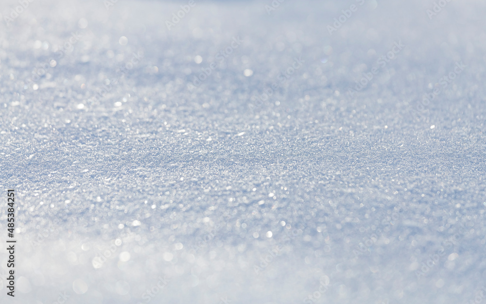 Obraz premium Close up macro photography texture of sparkling fresh white snow with light blue sky reflection tone. Selective focus. Winter christmas background.