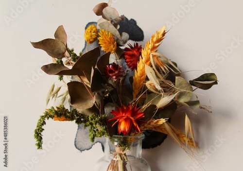 dried flowers of different colors in a glass vase