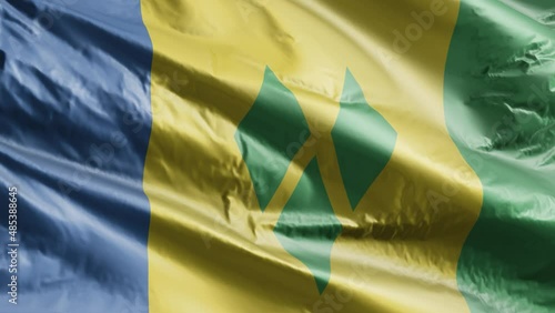 Saint Vincent and the Grenadines flag slow waving on the wind loop. Saint Vincent and the Grenadines banner smoothly swaying on the breeze. Full filling background. 20 seconds loop. photo