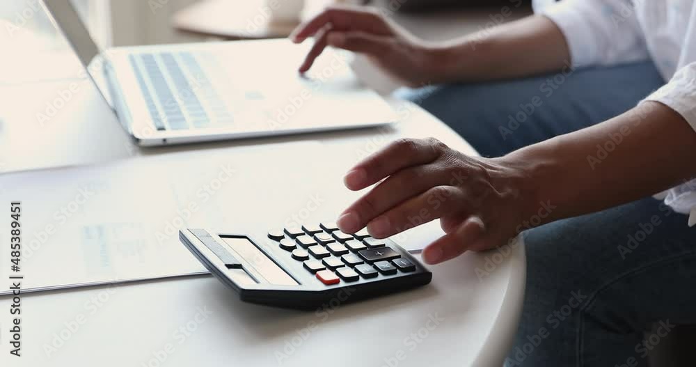 Close up cropped view woman paying bills on-line use computer, manage household finance or taxes use calculator, controlling family expenditures, makes payment through e-bank, Savings, finance concept Close up cropped view woman paying bills on-line use computer, manage household finance or taxes use calculator, controlling family expenditures, makes payment through e-bank, Savings, finance concept