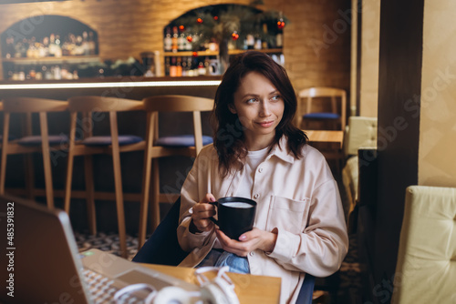 Woman with cup of coffee in cafe. Business work, education process, online communication, freelance concept