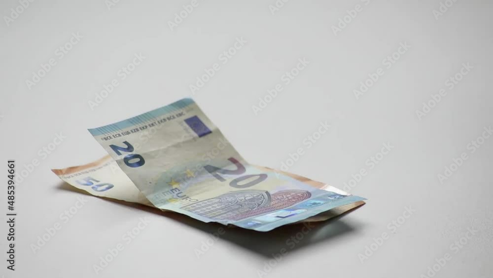 Hand of European man counting euro bank notes and euro coins on white desk with 10, 20 euro and 50 euro banknotes as income for financial investment and capital of crowd funding salary stack trade Hand of European man counting euro bank notes and euro coins on white desk with 10, 20 euro and 50 euro banknotes as income for financial investment and capital of crowd funding salary stack trade