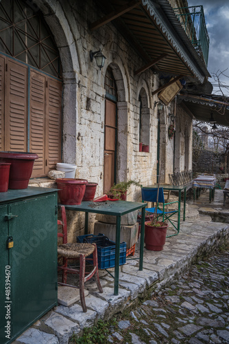 Old traditional chairs table and planters outside an abandoned stone building at the traditional village of Kalarites in Tzoumerka, Greece © Haris Photography