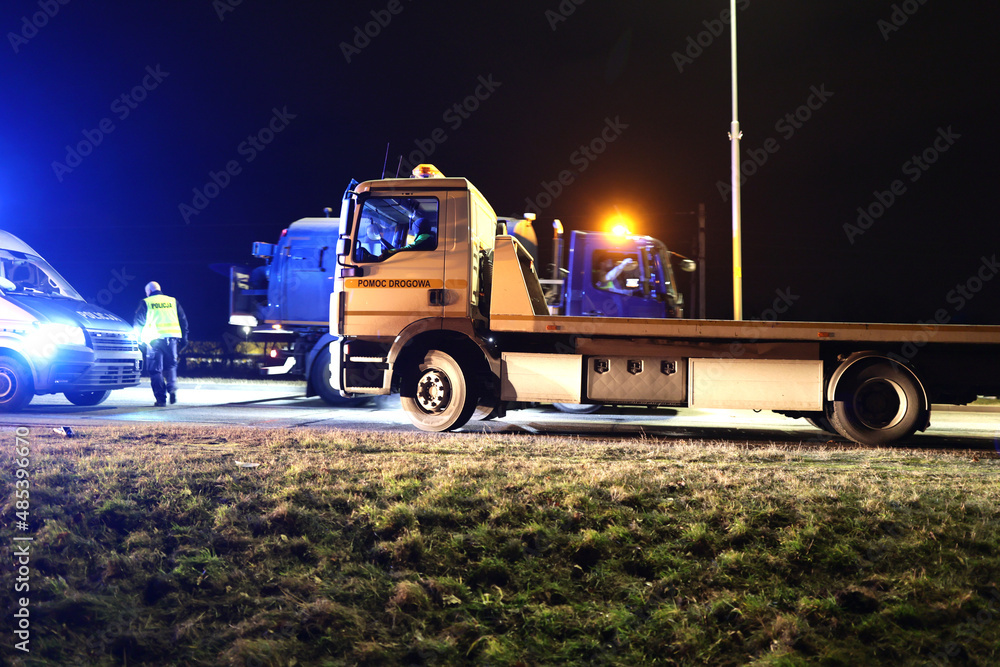 Samochód pomocy drogowej podczas obsługi wypadku drogowego w nocy na drodze.  - obrazy, fototapety, plakaty 