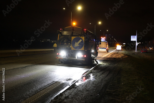 Samochód serwisu drogowego podczas obsługi wypadku drogowego w nocy na drodze. 