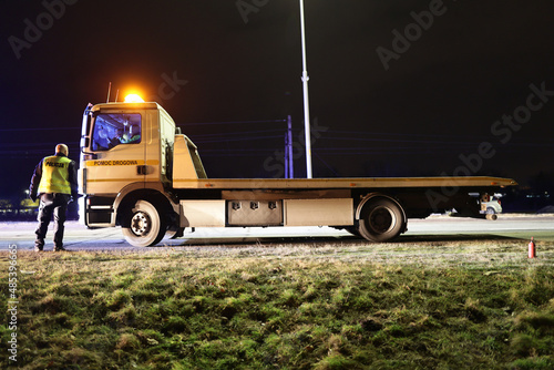 Samochód pomocy drogowej podczas obsługi wypadku drogowego w nocy na drodze. 