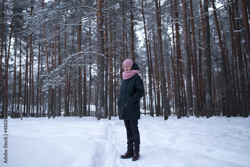 A woman in a pine park in a snowy winter. North of Russia.