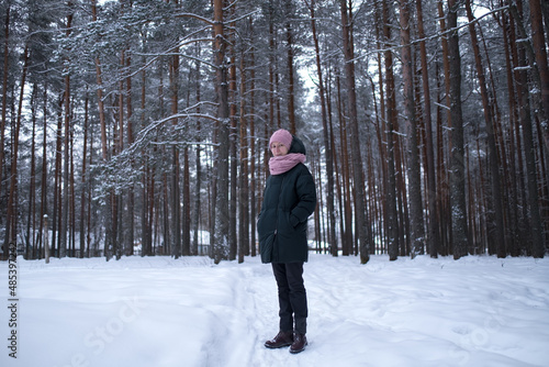 A woman in a pine park in a snowy winter. North of Russia.