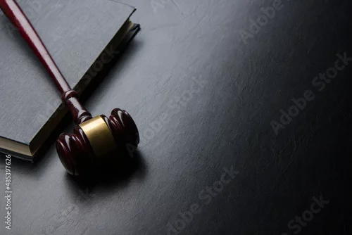 Obraz Legal Law and Justice concept - Open law book with a wooden judges gavel on table in a courtroom or law enforcement office. Copy space for text.