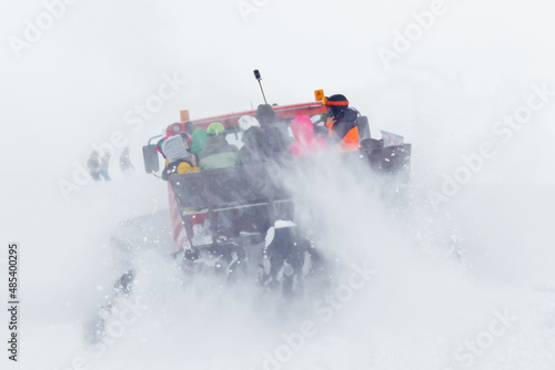People in the back of a snowcat are driving along a snowy road. Soft focus. ..