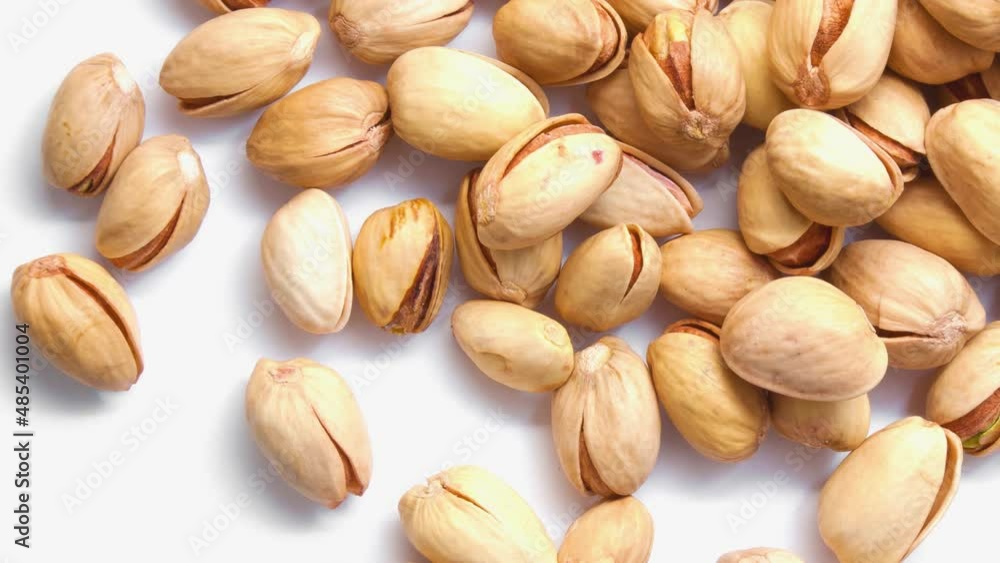 Bunch of spinning pistachios on a white background. View from above. Bunch of spinning pistachios on a white background. View from above.