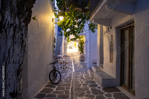Fototapeta Naklejka Na Ścianę i Meble -  Cafe outdoor illuminated lantern, shadow from trees at Paros island Naousa village Cyclades Greece.