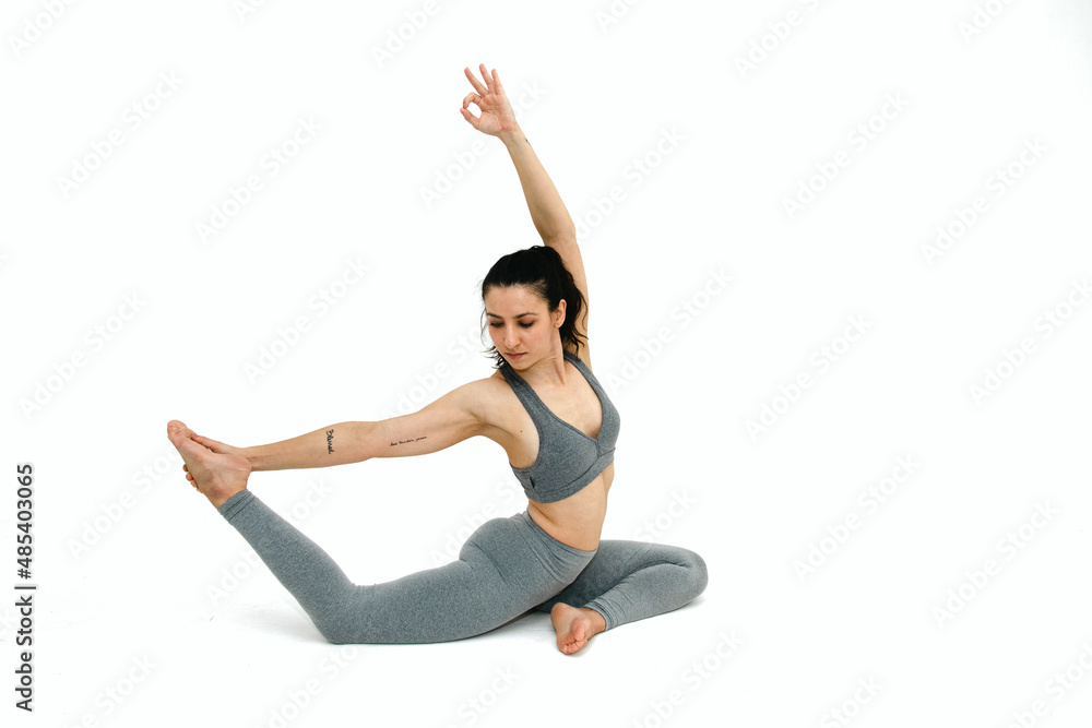 Woman doing yoga asana in white background. Black outfit. Ashtanga, Vinyasa, Hatha Woman doing yoga asana in white background. Black outfit. Ashtanga, Vinyasa, Hatha