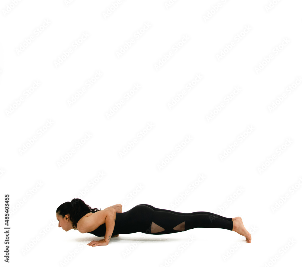 Woman doing yoga asana in white background. Black outfit. Ashtanga, Vinyasa, Hatha