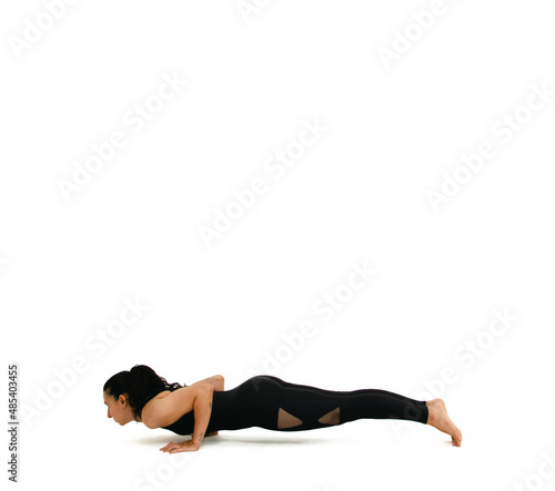 Woman doing yoga asana in white background. Black outfit. Ashtanga, Vinyasa, Hatha