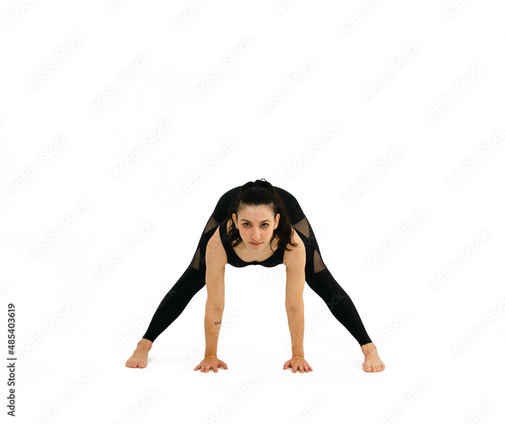 Woman doing yoga asana in white background. Black outfit. Ashtanga, Vinyasa, Hatha