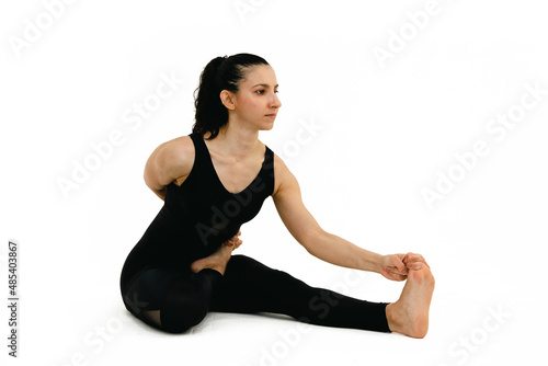 Woman doing yoga asana in white background. Black outfit. Ashtanga, Vinyasa, Hatha