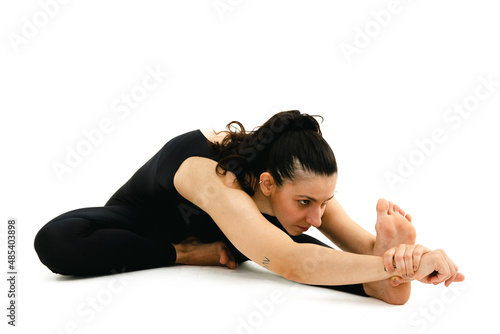Fototapeta Naklejka Na Ścianę i Meble -  Woman doing yoga asana in white background. Black outfit. Ashtanga, Vinyasa, Hatha