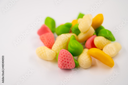 Close-up of a pile of a colorful jelly candies in the form of fruit on an isolated white background.