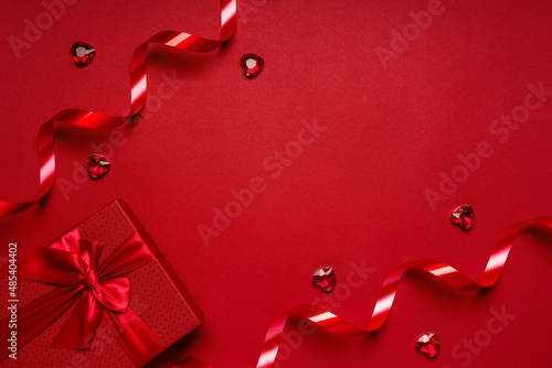 Red box, red ribbons, hearts on a red background, a romantic valentine's day gift for lovers.