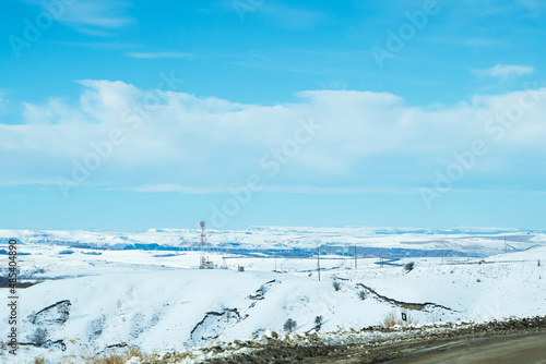 Photo from a mountain road with a view of the big sky and the mountain range in the distance