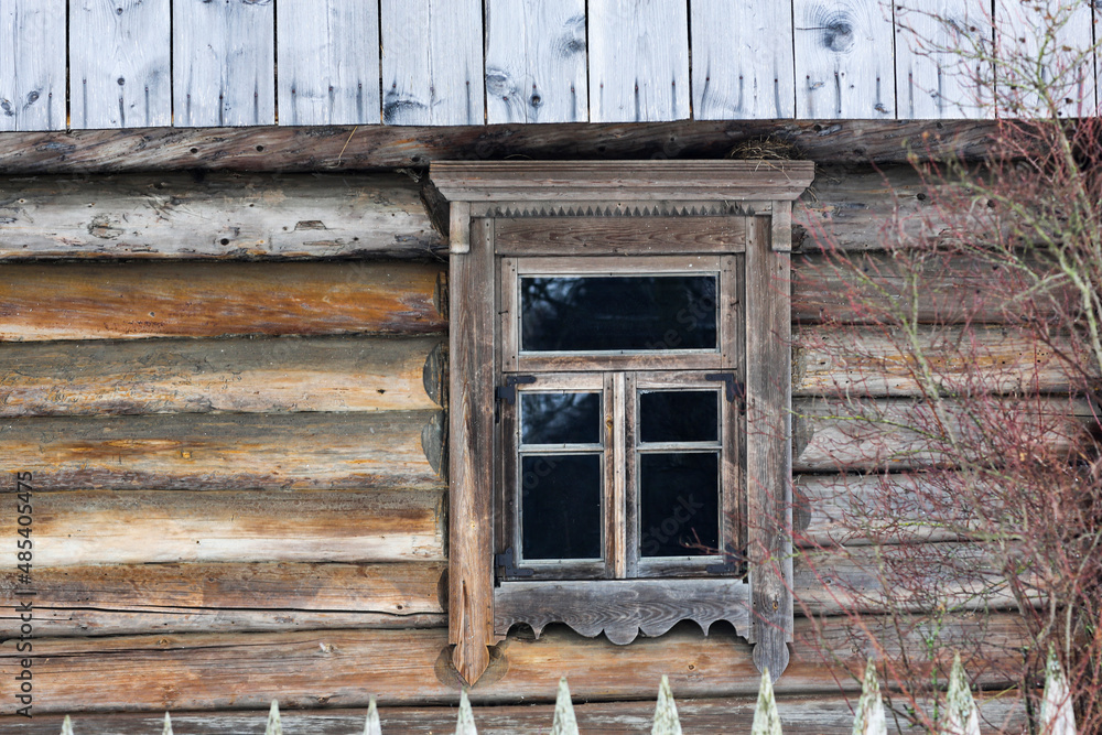 Rustic wooden house made of round logs. Abandoned villages and houses. Ancient window design. Wooden window frame. Snow covered village. Age-old buildings. Professional photography. Rustic wooden house made of round logs. Abandoned villages and houses. Ancient window design. Wooden window frame. Snow covered village. Age-old buildings. Professional photography.