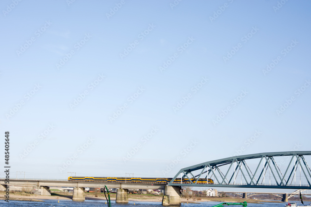 Train on rail bridge over the river Waal in Nijmegen in the Netherlands