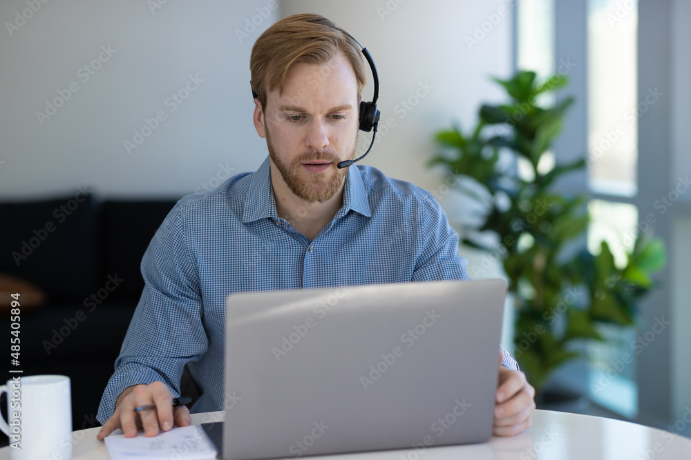 Caucasian man at home remote working on laptop computer talking with his colleague Caucasian man at home remote working on laptop computer talking with his colleague